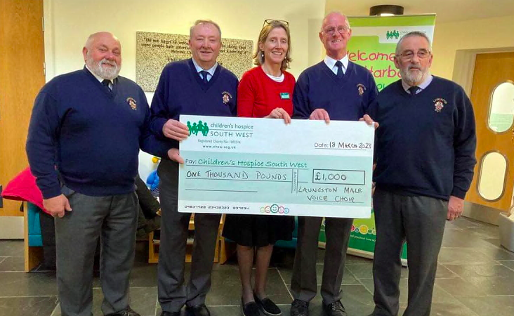 Pictured here are choir members who travelled to Little Harbour Hospice at St Austell to meet with Annabel Roberts (area fundraiser) and to proudly present a cheque for £1,000