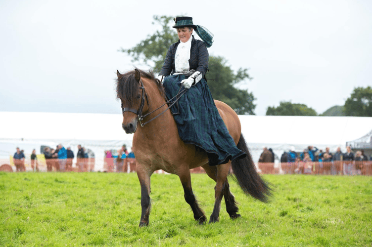 Women in traditional dress riding a horse at Woolsery.